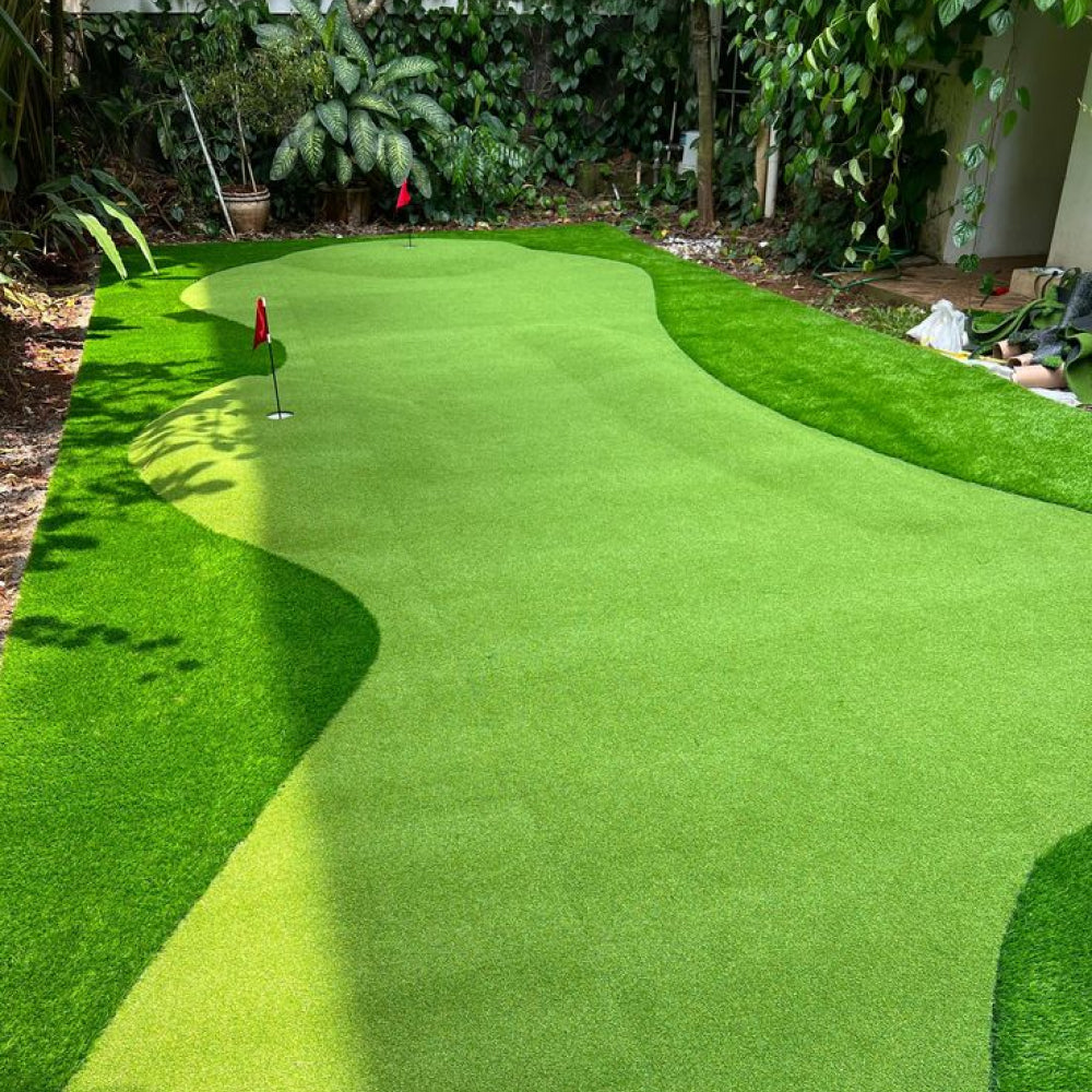 Artificial green grass with a golf flag on a well-maintained lawn