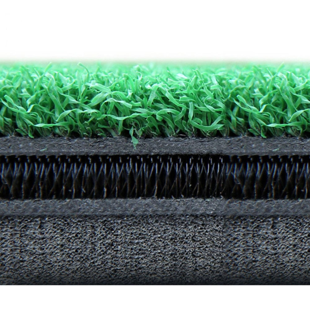 Close-up of green artificial grass and black and gray carpet fibers.