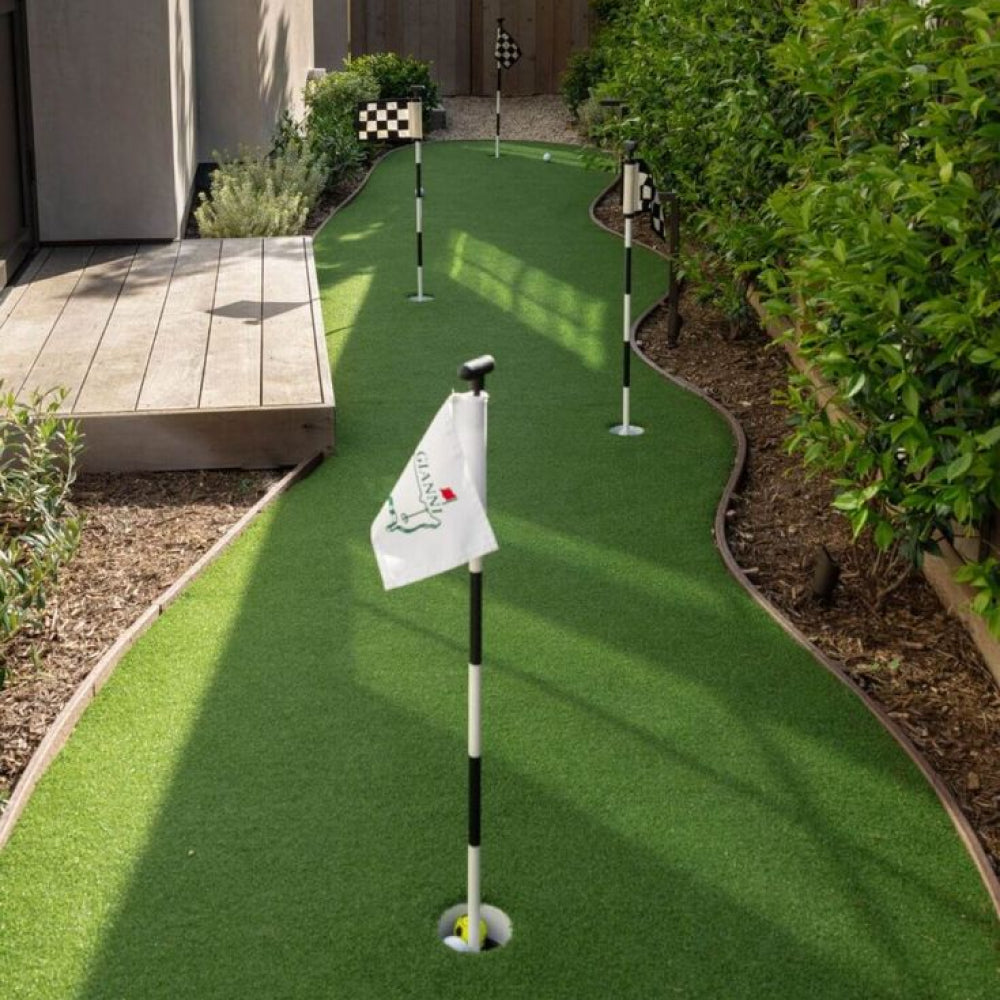 Miniature golf course with artificial grass and flags on a sunny day.