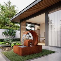Modern outdoor Mac Landscape's fountain in a garden setting with a house in the background