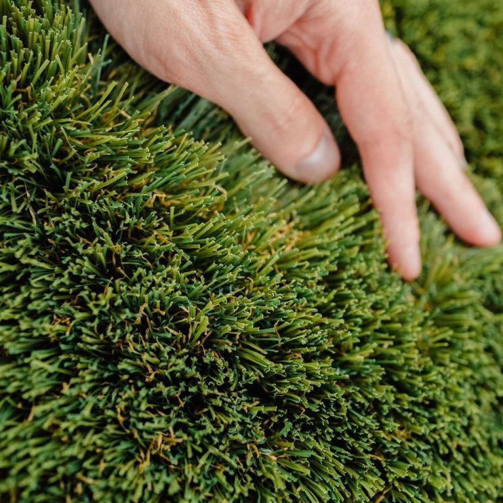 Hand touching artificial green grass
